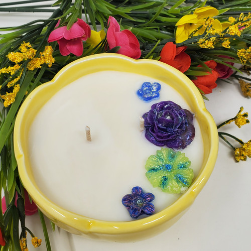 Yellow double wick container candle with white base candle and colorful glittery flowers