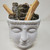 White ceramic Buddha Planter filled with smudge sticks and palo santo