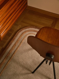 Arc rug in Amber, styled vignette with a mid-century wood chair