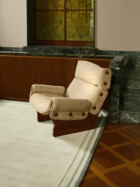 Arc rug in Spruce, styled vignette with an upholstered armchair beside a marble panel and stained-glass window
