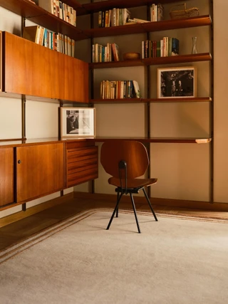 Arc rug in Amber, styled vignette in a wood-paneled library setting