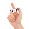 A white finger spinner held between fingers, featuring three black buttons on its surface.