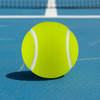A bright yellow tennis ball sits on a blue court, featuring white stripes and a smooth texture.
