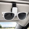 A black and white car visor sunglass holder with sunglasses attached, mounted on a car's visor.