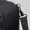 A black travel backpack with a textured surface, featuring a clip attachment and adjustable strap.
