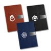 Three A5 notebooks in brown, black, and dark blue, each with a logo and a textured design on the cover.