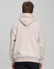A unisex premium fleece oversized hoodie in a light beige colour, featuring a hood and a branding logo on the back.