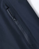 A close-up of a navy waterproof jacket showing a zippered pocket, with a sleek, modern design and a logo.
