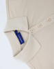 A beige ladies' classic cotton/poly pique short sleeve polo with a collar and buttons, featuring a branded label inside.