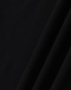 A close-up of black ultrafine cotton pique fabric, textured with a smooth finish. It features subtle folds.