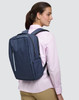 A navy blue backpack with a sleek design is worn on the back of a person, featuring zippers and compartments.