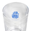 A clear glass carry cup featuring a decorative design inside and a smooth surface. It has a logo on the inside.
