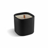 A premium square glass candle in a sleek black container with a wooden wick.
