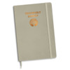 A light grey notebook with a foil printed design and an emblem. It features a binding and an elastic closure.