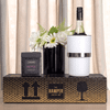 A wine bottle in a white cooler, paired with a black box of brittle, set on a decorative box with a logo.