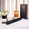 A black umbrella set displayed with assorted product boxes and a floral arrangement on a table.