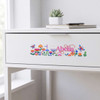 A drawer with a white finish featuring a colourful floral sticker with butterflies and the name "Abelia".