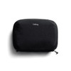 A black tech kit with a zip closure and a logo on the front, featuring a sleek, minimalist design.