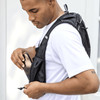 A black recycled running vest hydration pack being worn by a man, featuring mesh pockets for storage.