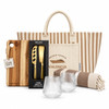 A tote bag with stripes, a wooden cheese board, a two-piece cheese set, two textured glasses, and a striped blanket.
