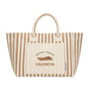 A striped tote bag in beige and cream with a logo and a large front pocket.