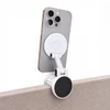 A white Tutor Maglock phone holder attached to the edge of a surface, holding a smartphone securely in place.