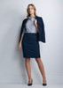 A woman in a navy 3/4 sleeve shirt and matching skirt stands confidently, wearing a blazer and high heels.
