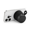 A black, cylindrical speaker with a textured surface, positioned against a smartphone. The speaker has a carrying strap.