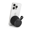 A black speaker connected to a smartphone, featuring a textured fabric exterior and a loop for attachment.