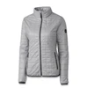 A light grey women's jacket with a quilted design, featuring a zip front and side pockets. It has a logo on the sleeve.