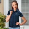 A navy women's polo shirt featuring a logo, designed for performance. The model showcases a casual style against an indoor backdrop.
