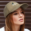 A cap in khaki with a branded logo, featuring a curved peak and textured fabric, worn by a model.
