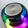 A Bluetooth speaker with a sleek, rounded design featuring vibrant, multicoloured lights and a metallic speaker grill on top.