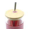 A drink bottle with a pink sleeve, bamboo lid, and a metal straw. It features a logo on the side.
