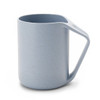 A reusable coffee cup in light blue, featuring a unique handle design and a textured surface. It has a logo.