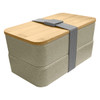 A wheat straw lunch box pack in a light beige colour, featuring a bamboo lid and a grey strap.