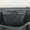 An interior view of a black nylon shopping tote featuring a zippered pocket. The bag has a smooth, structured design.
