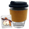 A glass coffee cup with a cork band, accompanied by a mixed bag of colourful jelly lollies.