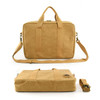 A tan satchel with dual handles, a detachable strap, and a logo, featuring a smooth, textured surface.
