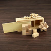 A wooden brain teaser puzzle set featuring various geometric blocks and wooden beads, set on a dark wooden surface.