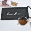 A black microfiber pouch with a logo, accompanied by brown-tinted sunglasses.