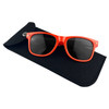 A pair of black sunglasses with vibrant red frames resting on a black felt pouch featuring a closure.