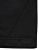 A close-up view of the hem of a black polo shirt, featuring subtle stitching details and a logo.