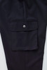 A close-up of black women's cargo pants featuring a side pocket with a button closure and a smooth fabric finish.