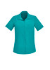 A short sleeve women's shirt in teal, featuring a collar and a pocket. It has a button-up front and branding.