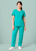 A women's scrub top in teal, featuring a round neck and two front pockets, styled with matching pants.