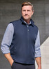 A man wearing a navy blue unisex reversible fleece vest, standing against a concrete background. The vest has a zip and a collar.