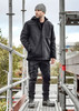 A black unisex softshell jacket worn by a man on scaffolding, with a beanie and work pants, set outdoors.