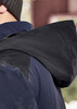 A waterproof jacket in navy blue with a dark hood, featuring a logo on the back.