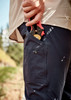 Lightweight navy cargo pants with a pocket holding gardening shears, worn with a light-coloured shirt, set in an outdoor environment.